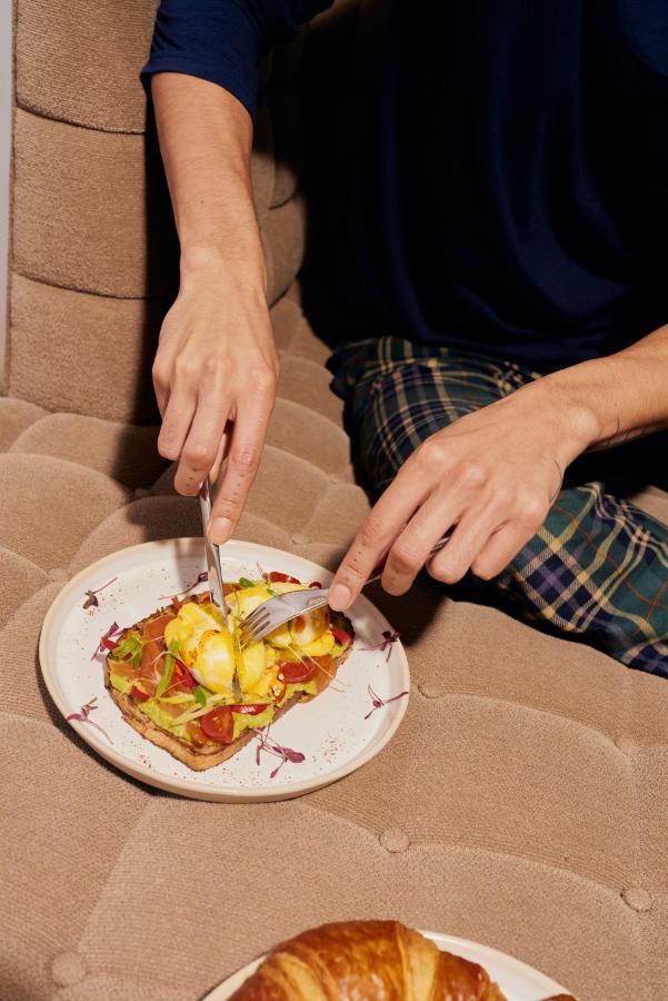 โรงแรมแซนเดอร์สัน ลอนดอน ภายนอก รูปภาพ A person using a knife and fork to cut food