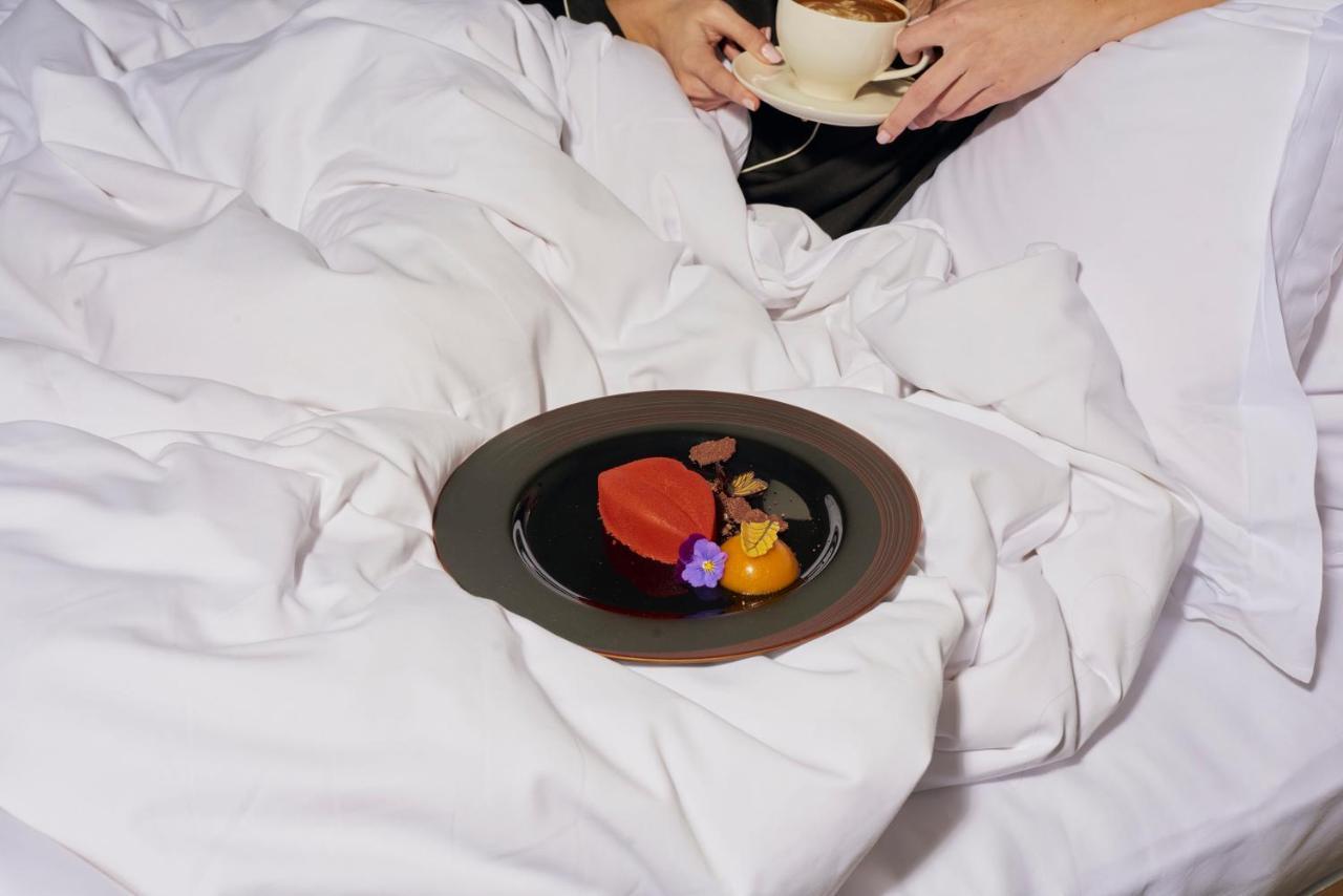 โรงแรมแซนเดอร์สัน ลอนดอน ภายนอก รูปภาพ A woman eating a heart-shaped dessert